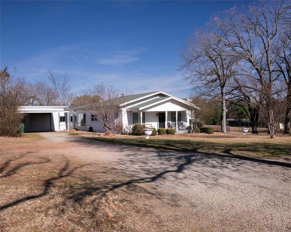 a front view of a house with yard and parking