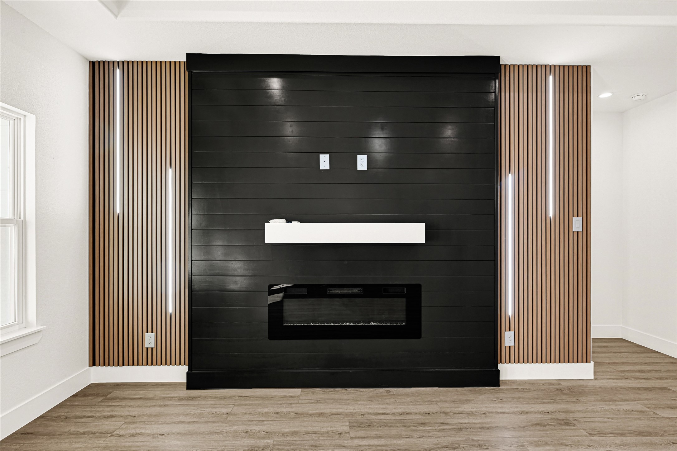 105 Bledsoe Street Prairie View, TX 77446 - Photo 10 of 35 Electric fireplace with decorative wall panels and modern lights