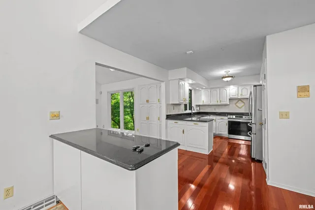 a kitchen with stainless steel appliances a stove microwave and sink