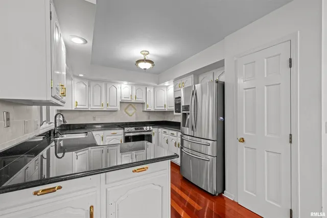 a kitchen with granite countertop white cabinets and a large window