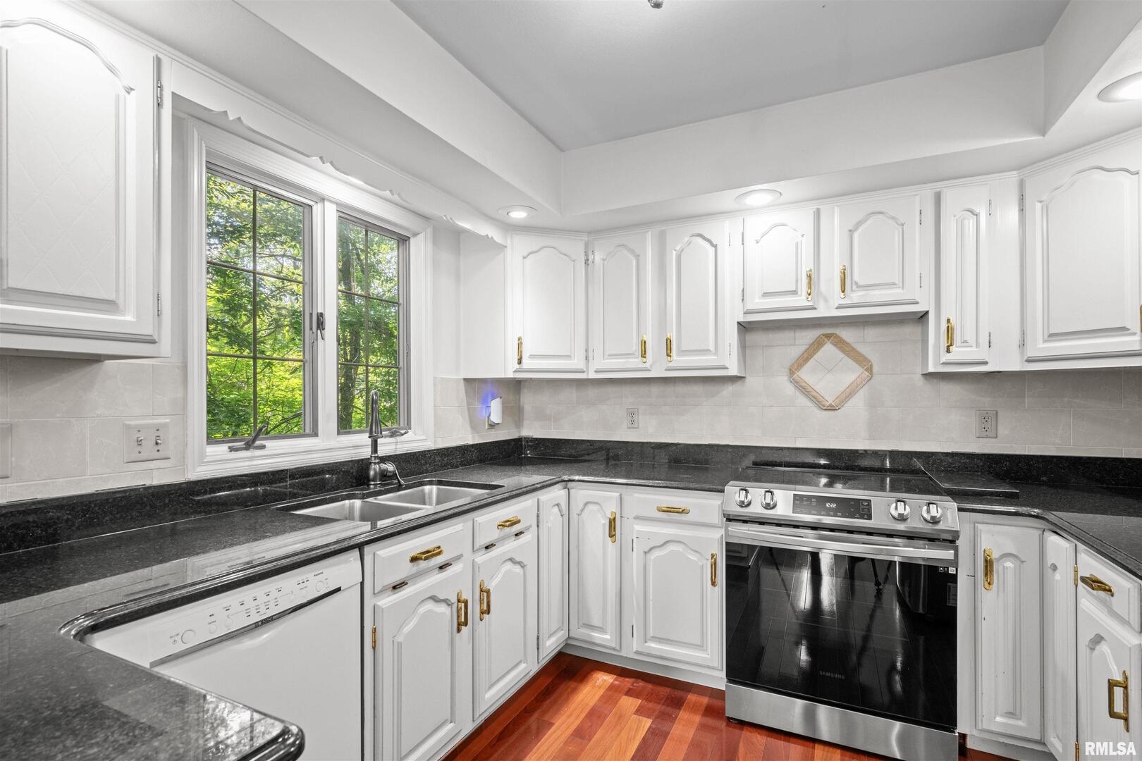 5 White Oak Court Moline, IL 61265 - Photo 19 of 57 a kitchen with granite countertop white cabinets and a window