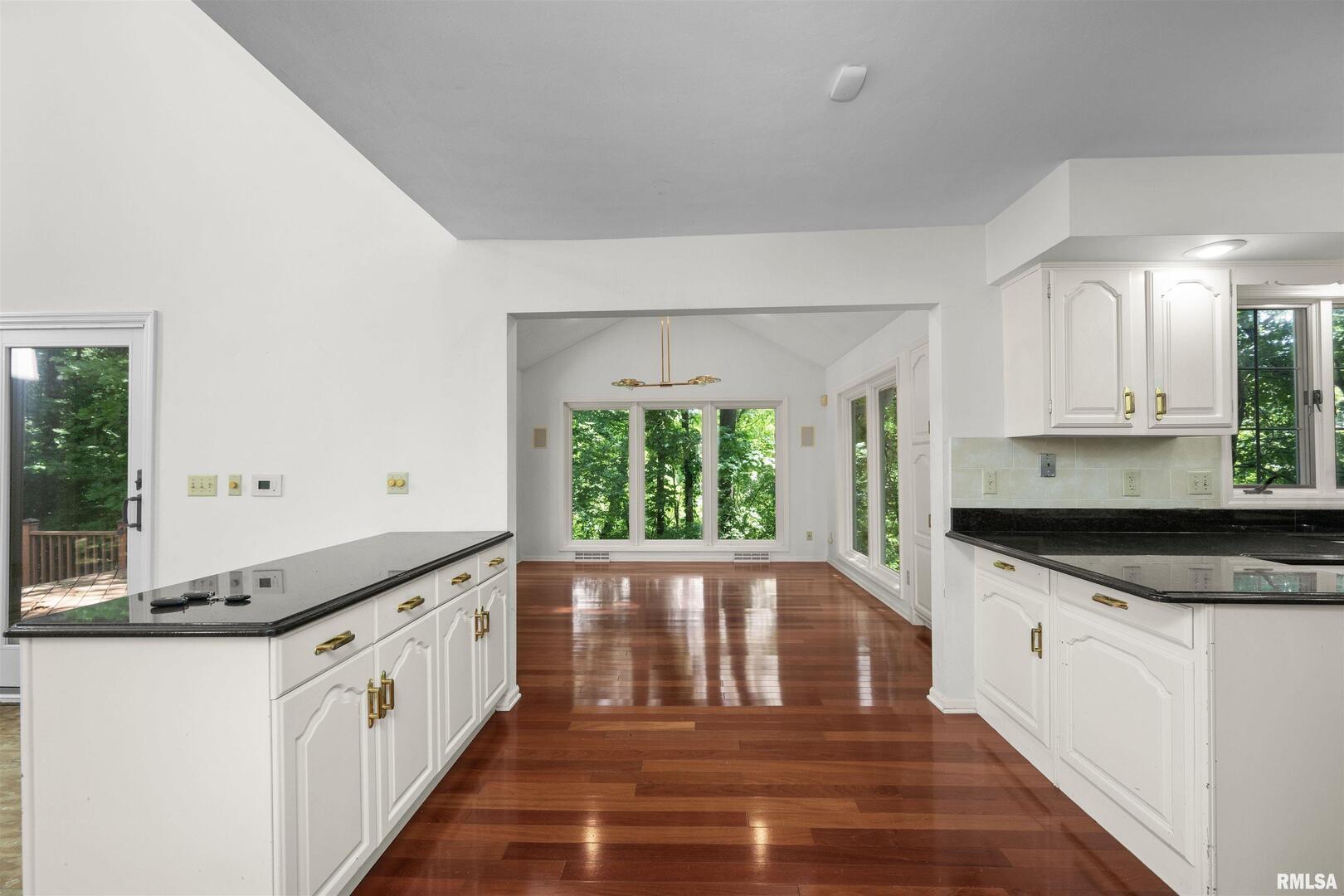 5 White Oak Court Moline, IL 61265 - Photo 22 of 57 a kitchen with granite countertop white cabinets and a large window