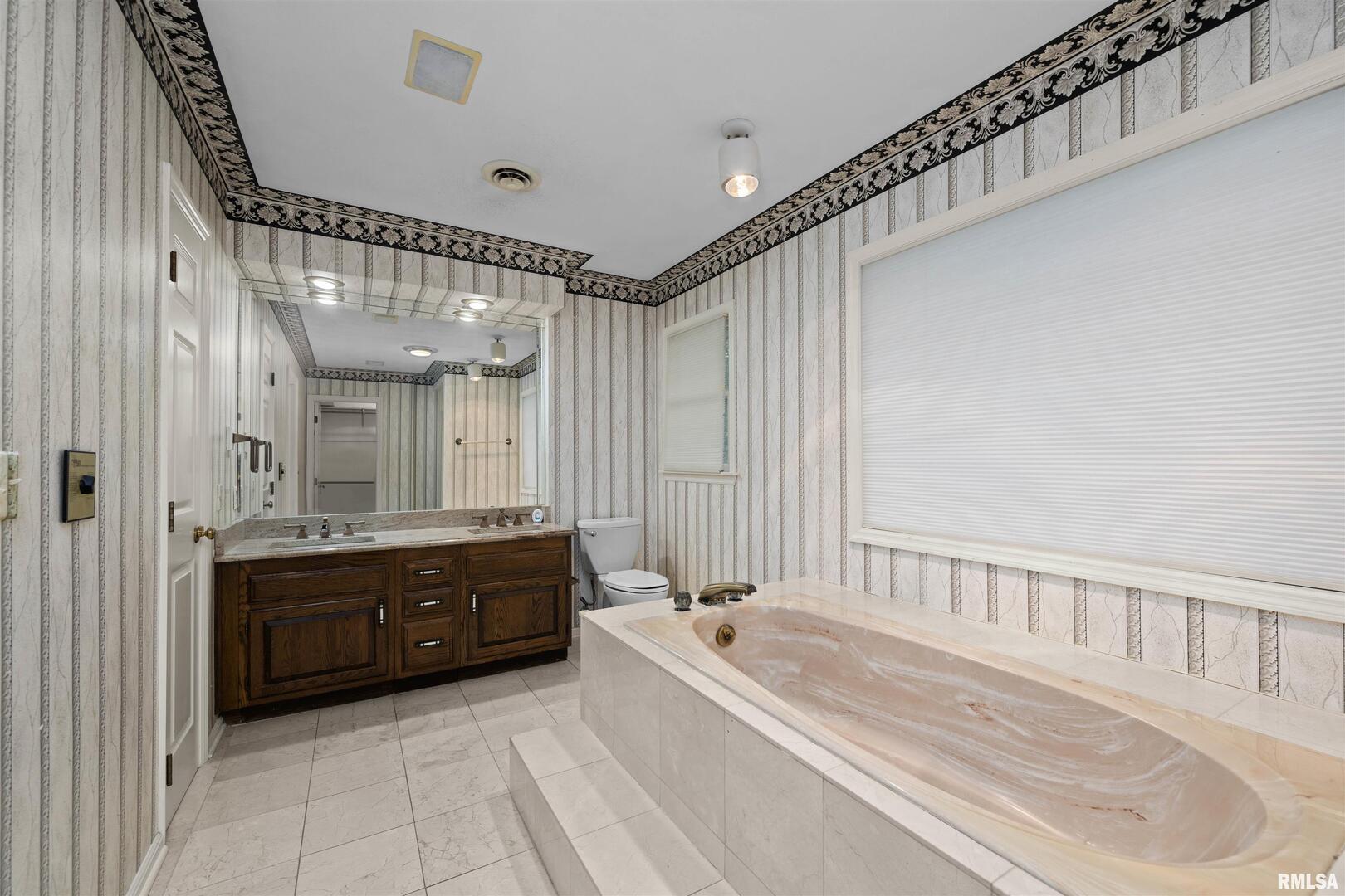 5 White Oak Court Moline, IL 61265 - Photo 38 of 57 a spacious bathroom with a tub sink and mirror