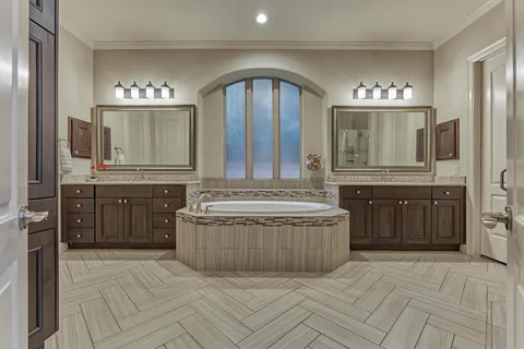 a bathroom with a granite countertop bathtub a double vanity sink and mirror