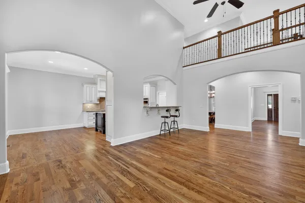 a kitchen with stainless steel appliances granite countertop a stove a sink and white cabinets next to a window