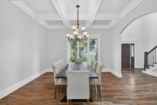 a large kitchen with a center island wooden floor stainless steel appliances and cabinets