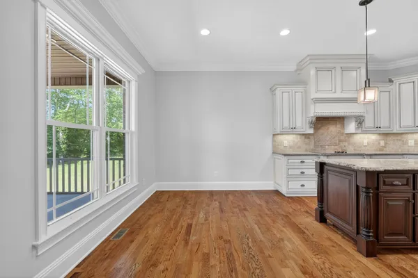 a kitchen with stainless steel appliances granite countertop a refrigerator a oven and a sink with wooden floor