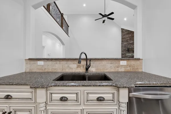 a bathroom with a granite countertop shower a sink and a mirror