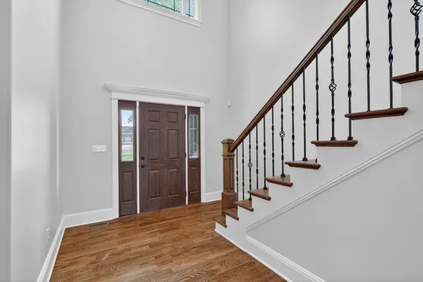 an empty room with wooden floor fireplace and windows