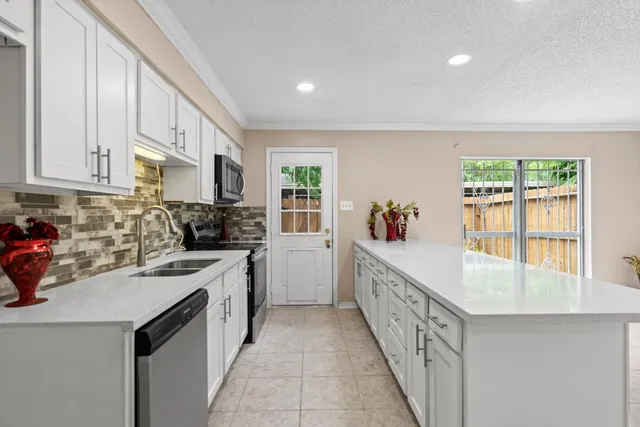 a kitchen with stainless steel appliances a stove a sink a microwave and cabinets
