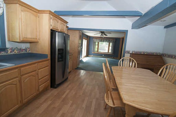 4 Shaw Street Medway, MA 02053 - Photo 9 of 25 a kitchen with granite countertop a refrigerator a stove a sink a dining table and chairs with wooden floor
