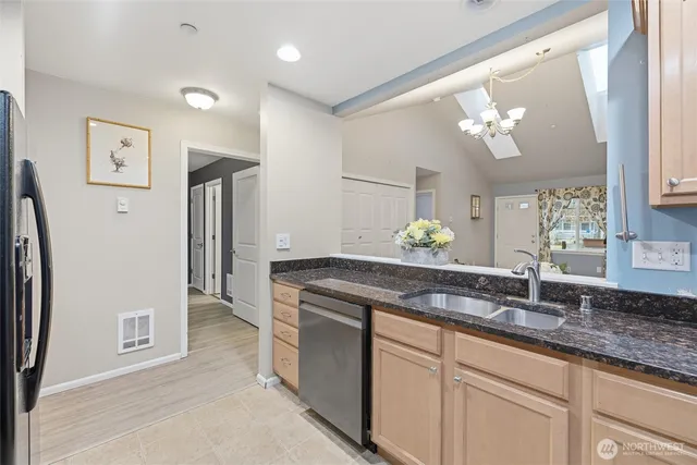 a kitchen with stainless steel appliances granite countertop a refrigerator a stove and a sink