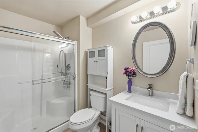 a bathroom with a sink vanity granite toilet and a mirror