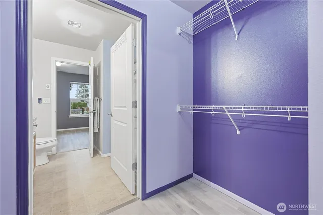 a view of a hallway with wooden floor and closet