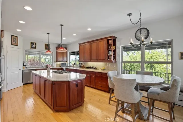 a kitchen with kitchen island granite countertop a sink stove and wooden cabinets