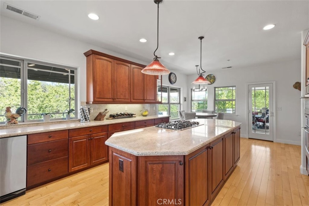 3217 Shallow Springs Terrace Chico, CA 95928 - Photo 16 of 55 a kitchen with kitchen island granite countertop a sink stove and wooden cabinets