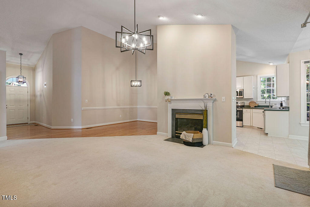 125 Chimney Rise Drive Cary, NC 27511 - Photo 12 of 41 a view of a livingroom with a fireplace a chandelier and windows