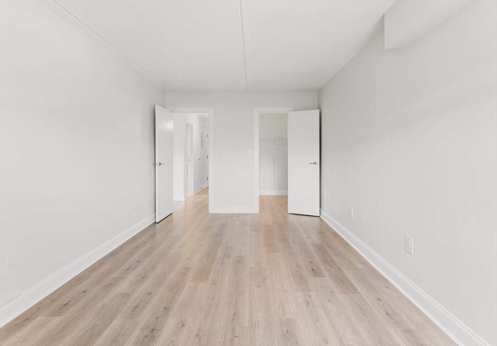275 Main Street, Unit 404 Watertown, MA 02472 - Photo 29 of 39 a view of an empty room and wooden floor