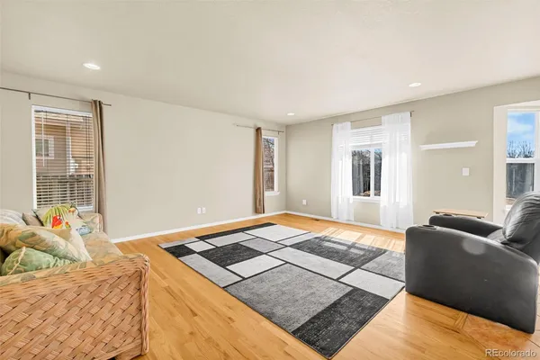 a bedroom with a bed lamp and wooden floor