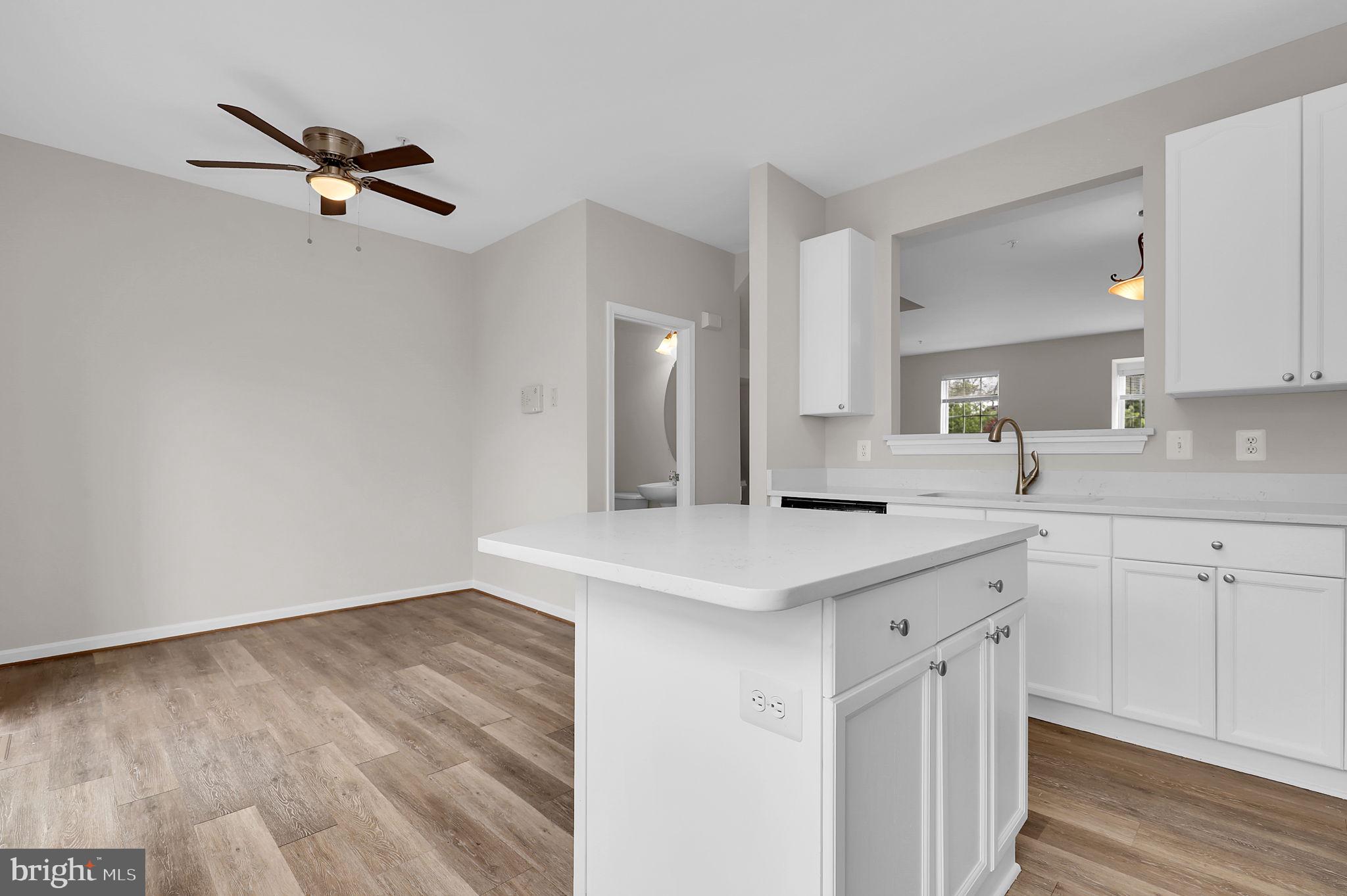 2475 Lakeside Drive Frederick, MD 21702 - Photo 5 of 40 a kitchen with a sink dishwasher and white cabinets with wooden floor