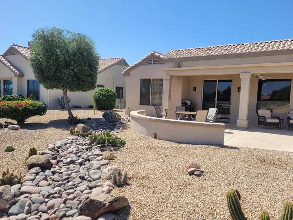 a view of a house with backyard and sitting area