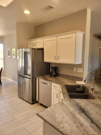 a kitchen with stainless steel appliances granite countertop a refrigerator sink and stove