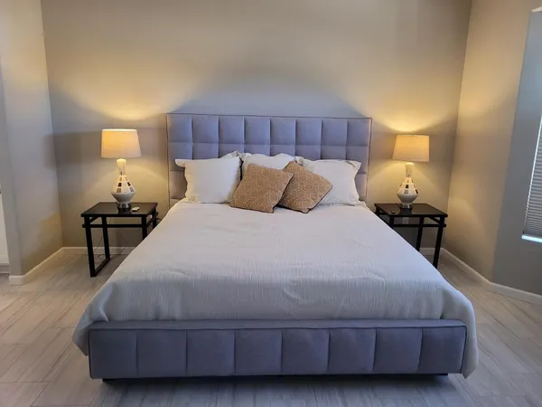 a large bed sitting in a bedroom next to a lamp