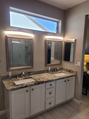 a bathroom with a granite countertop sink double and mirror