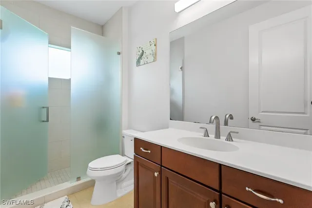 a bedroom with a bed and a lamp on dresser