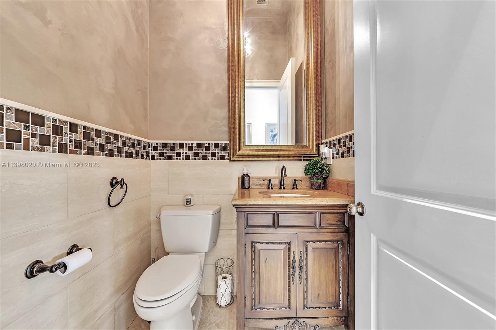 731 Ranch Road Weston, FL 33326 - Photo 14 of 53 a bathroom with a toilet a sink and mirror