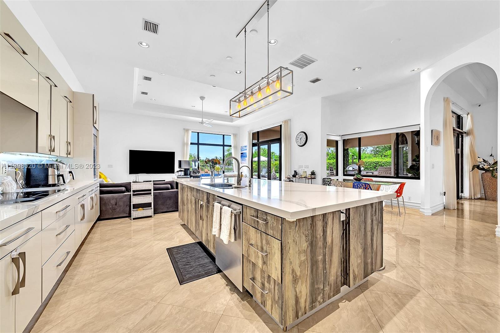 731 Ranch Road Weston, FL 33326 - Photo 7 of 53 a large kitchen with stainless steel appliances kitchen island granite countertop a lot of counter space and wooden floor