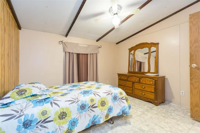 a bedroom with a bed and a mirror on dresser