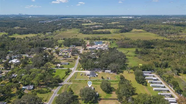 an aerial view of house with yard and mountain view in back