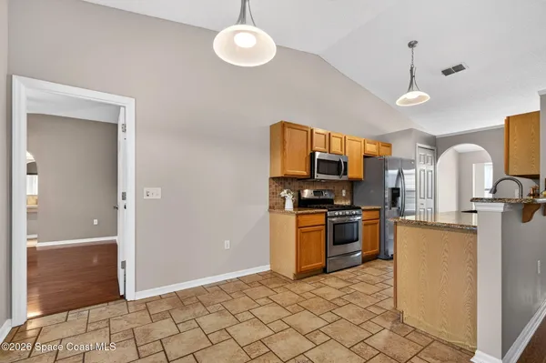 a kitchen with stainless steel appliances granite countertop a refrigerator a stove top oven and sink
