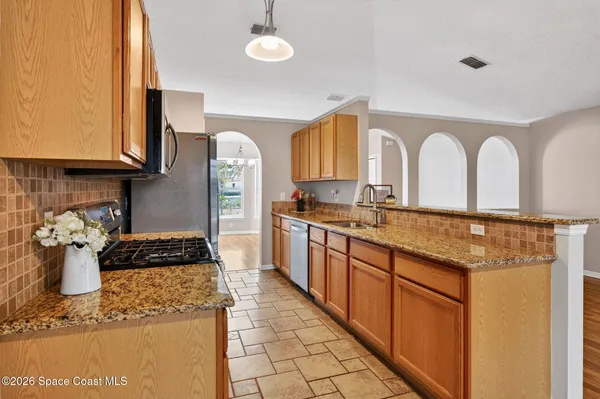 a kitchen with a sink a stove and cabinets