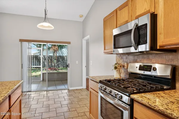 a kitchen with a stove a microwave and wooden floor
