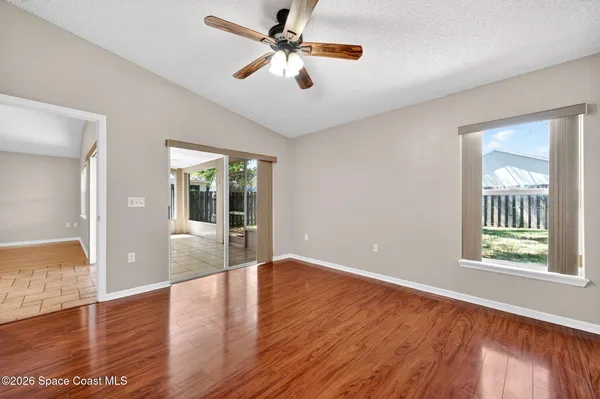 a view of an empty room with window and wooden floor