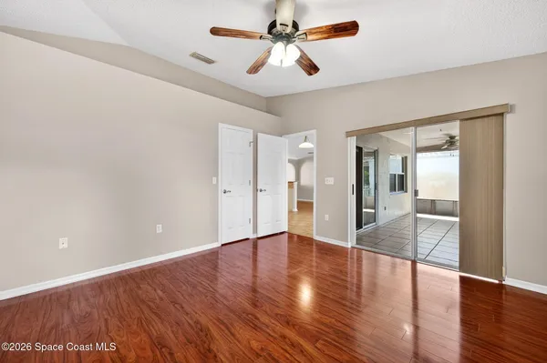 a view of an empty room with wooden floor