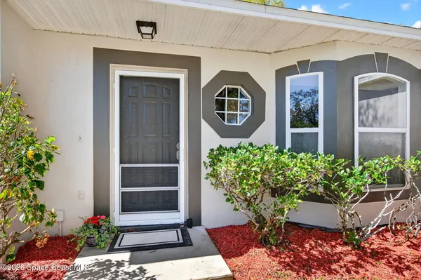 a front view of a house with a flower garden