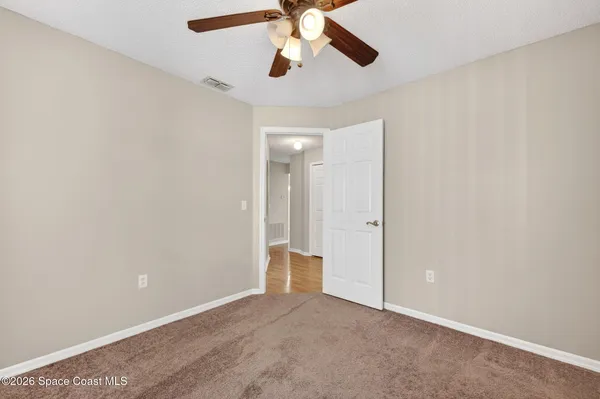 an empty room with closet and a chandelier fan