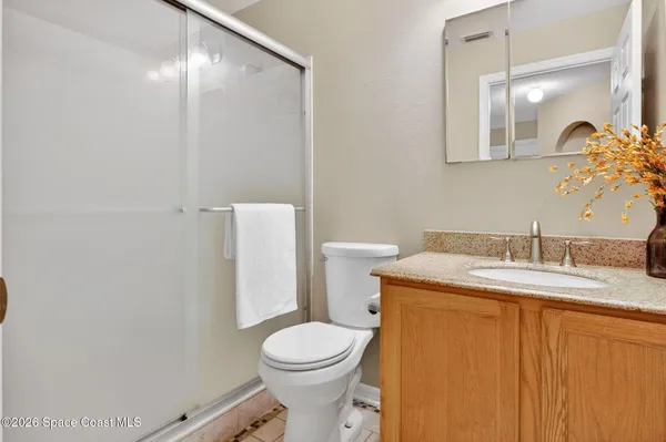 a bathroom with a granite countertop sink mirror vanity and toilet