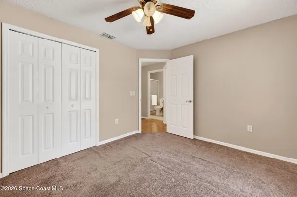 an empty room with chandelier fan