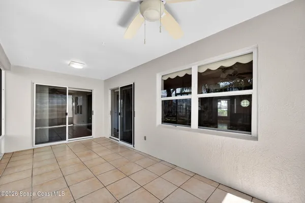 a view of an empty room with window and stairs