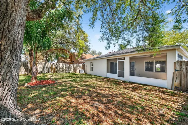a view of a yard with wooden fence and a large tree