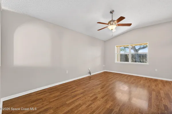 a view of empty room with wooden floor