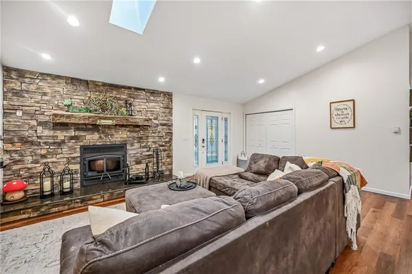 a room with stainless steel appliances lots of furniture and wooden floors