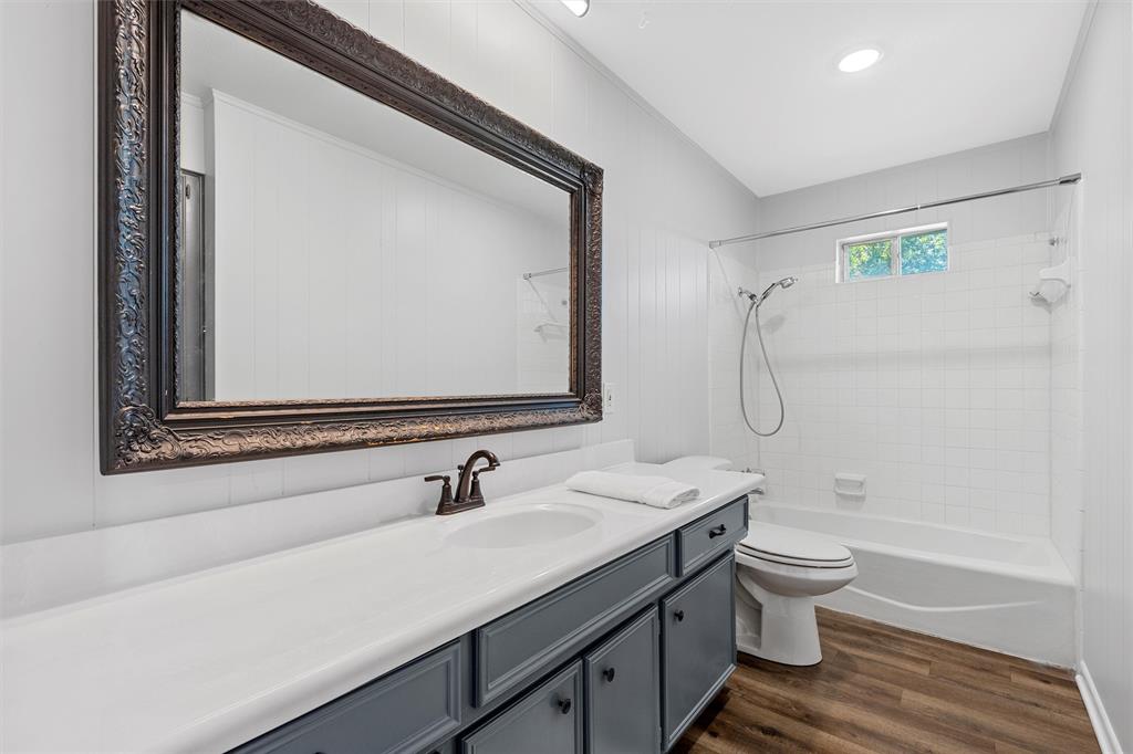 2988 East Old Axtell Road Axtell, TX 76624 - Photo 15 of 38 a bathroom with a double vanity sink toilet mirror and bathtub