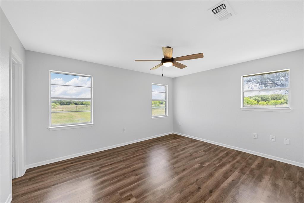 2988 East Old Axtell Road Axtell, TX 76624 - Photo 16 of 38 a view of an empty room with wooden floor and a window