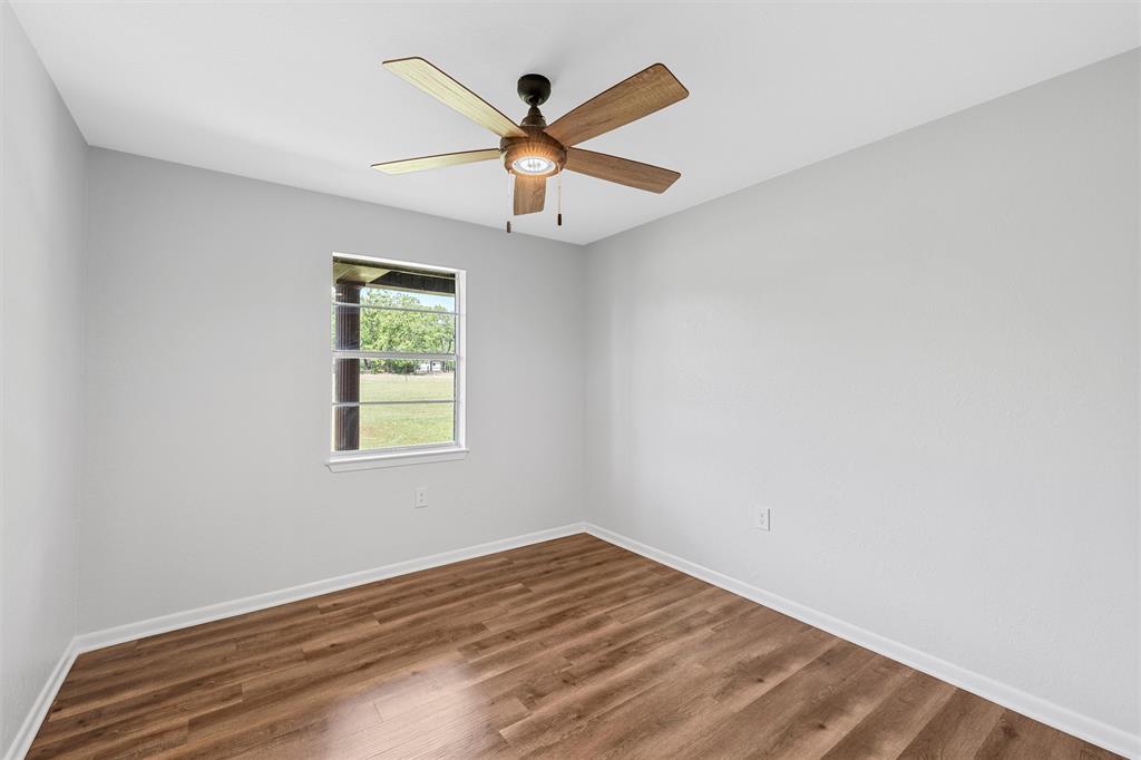 2988 East Old Axtell Road Axtell, TX 76624 - Photo 21 of 38 an empty room with wooden floor window and ceiling fan