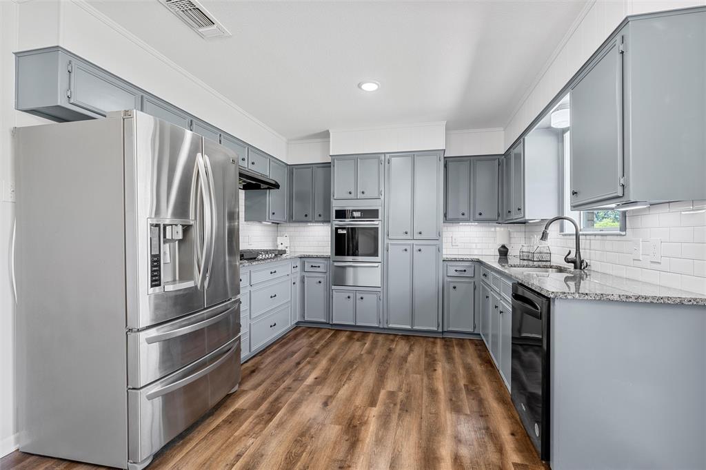2988 East Old Axtell Road Axtell, TX 76624 - Photo 9 of 38 a kitchen with granite countertop stainless steel appliances and wooden cabinets